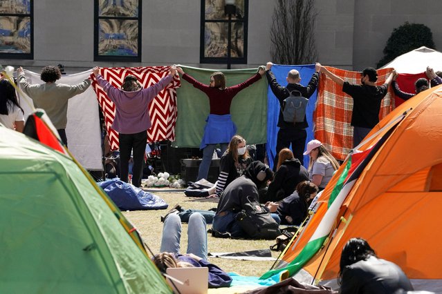 A group of students cover the area where others gathered to pray while taking part in a student protest encampment in support of Palestinians at the Columbia University campus, during the ongoing conflict between Israel and the Palestinian Islamist group Hamas, in New York City on April 26, 2024. (Photo by David Dee Delgado/Reuters)
