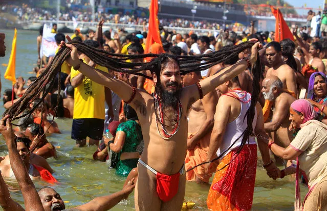 A Hindu holy man displays his hair after taking a dip in the waters of the river Shipra during the Simhastha Kumbh Mela in Ujjain, India, April 22, 2016. (Photo by Jitendra Prakash/Reuters)