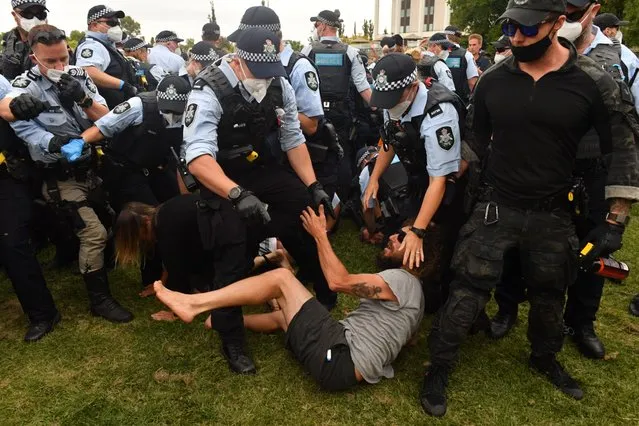 Police scuffle with a “freedom” protester at a makeshift camp next to the National Library, in Canberra, Australia, 02 February 2022. A group of anti-vaccination protesters who targeted the prime minister will be moved on from an unapproved camp near the National Library. (Photo by Mick Tsikas/EPA/EFE)