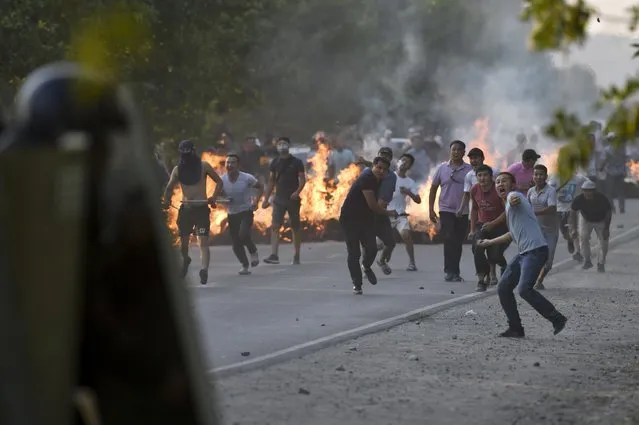 Supporters of former president Almazbek Atambayev throw rocks as they fight with riot police near Atambayev's residence in the village of Koi-Tash, about 20 kilometers (12 miles) south of the capital, Bishkek, Kyrgyzstan, Thursday, August 8, 2019. (Photo by Vladimir Voronin/AP Photo)