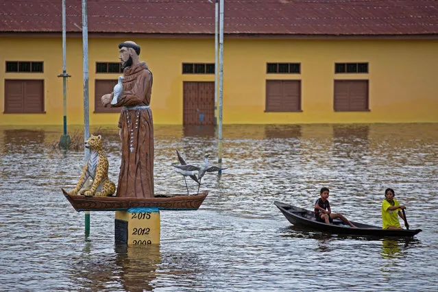 People man sale on a boat trough the flooded streets due to the Solimoes river overflow in Anama town, Amazon, Brazil on May 19, 2021. (Photo by Michael Dantas/AFP Photo)
