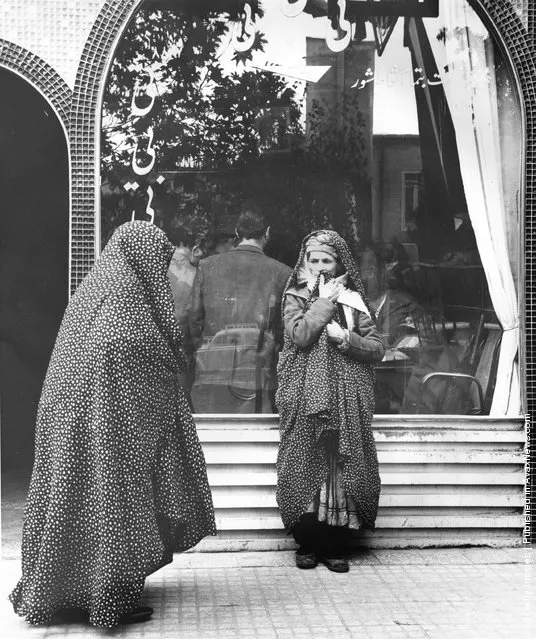 1955:  Iranian women wait outside whilst the men meet in a teashop in Mashad, Iran