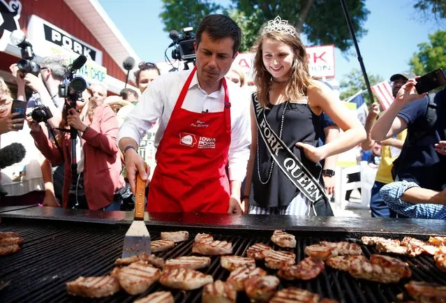2020 Democratic U.S. presidential candidate and South Bend Mayor Pete Buttigieg grills at the Iowa Pork Producers tent at the Iowa State Fair in Des Moines, Iowa, August 13, 2019. Democratic presidential hopefuls mingle with Iowa voters, seeking the momentum needed to catapult their campaigns in the critical state, which will hold the first nominating contest in February 2020. (Photo by Eric Thayer/Reuters)