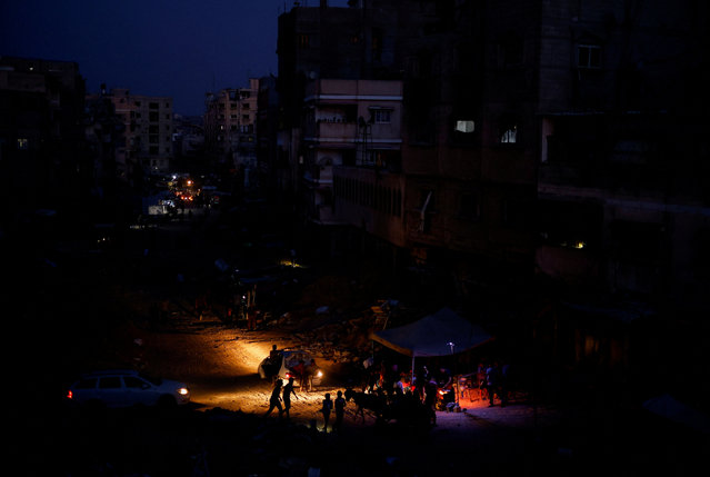 Palestinians gather amid power cut near houses damaged during Israel's military offensive, in Khan Younis, in the southern Gaza Strip, on May 28, 2024. (Photo by Mohammed Salem/Reuters)
