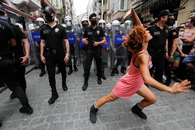 A demonstrator dances as riot police try to prevent LGBT rights activists gather for a Pride parade, which was banned by local authorities, in central in Istanbul, Turkey on June 26, 2021. (Photo by Dilara Senkaya/Reuters)