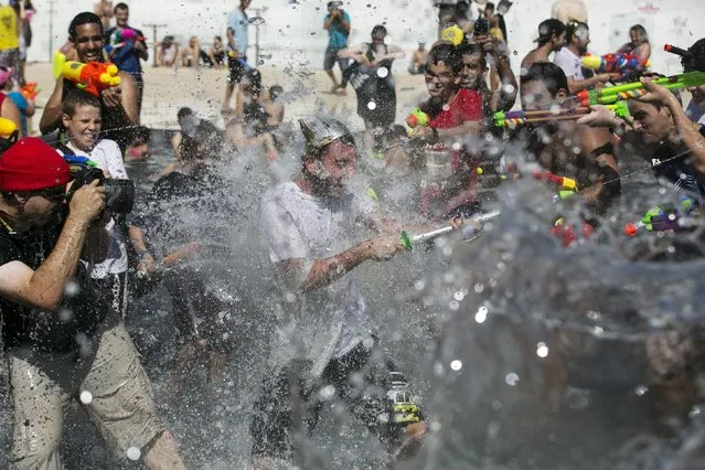 Participants splash water during a water fight in Tel Aviv, July 10, 2015. (Photo by Baz Ratner/Reuters)