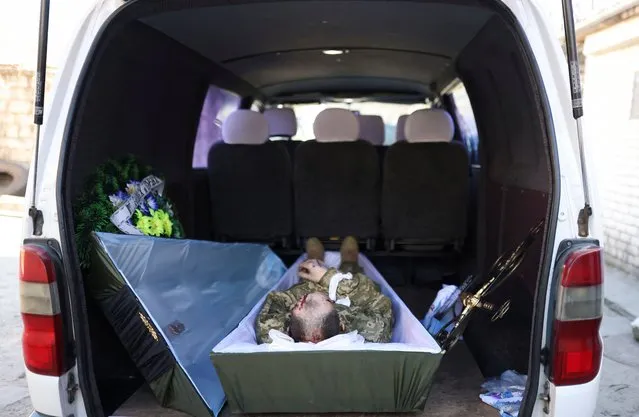 The mortal remains of Inna, 39, a Ukrainian service member, is pictured inside a van at a morgue before being taken to his house, as Russia's invasion of Ukraine continues, in Mykolaiv, Ukraine, March 21, 2022. (Photo by Nacho Doce/Reuters)