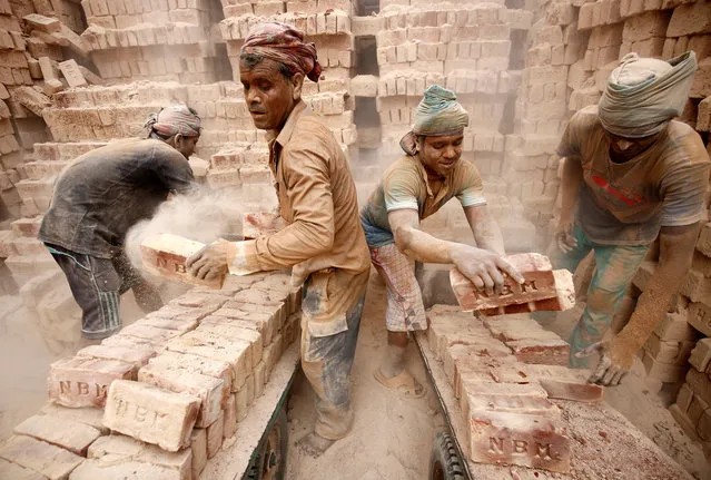 Brick factory workers load carts with bricks to take them into warehouse in Dhaka, Bangladesh, April 19, 2017. (Photo by Mohammad Ponir Hossain/Reuters)