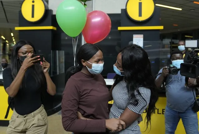 South African student Vutlhari Mtonga, centre left, who was evacuated from Ukraine following Russian invasion, is welcomed by her sister Mikateko Mtonga, on arrival at OR Tambo International Airport, in Johannesburg, South Africa, Thursday, March 10, 2022. (Photo by Themba Hadebe/AP Photo)
