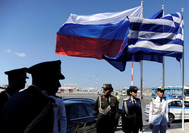 Greek police and army officers stand by Greek, Russian and EU flags as they wait for the arrival of Russian President Vladimir Putin in Athens, Greece airport, May 27, 2016. (Photo by Michalis Karagiannis/Reuters)