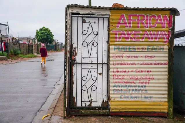 A woman walks past a take away kiosk made out of a shipping container in a township in Mossel Bay, South Africa 30 March 2022. Africa has a diverse mix of culinary influences, part tribal heritage part colonial influence its tastes and aromas range widely. Traditionally the various cuisines of Africa use a mixture of plant and seed based with meat also very popular. The roots of African cuisine date back thousands of years to the Bronze Age. The multitude of dishes are also heavily influenced by the crops grown and readily available in the areas they are consumed. (Photo by Nic Bothma/EPA/EFE)