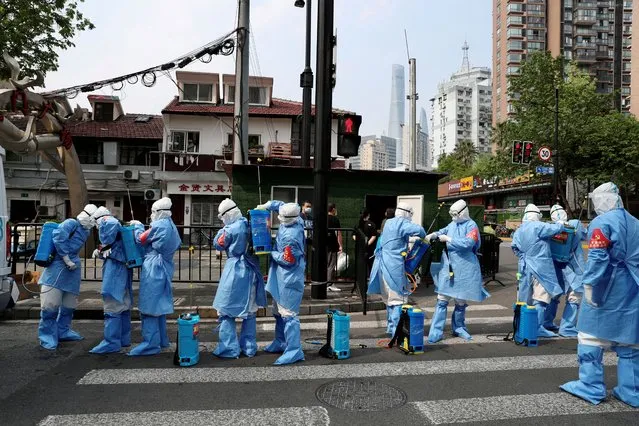 Workers in protective suits prepare to disinfect a residential compound in Huangpu district, following the coronavirus disease (COVID-19) outbreak in Shanghai, China on April 20, 2022. (Photo by China Daily via Reuters)