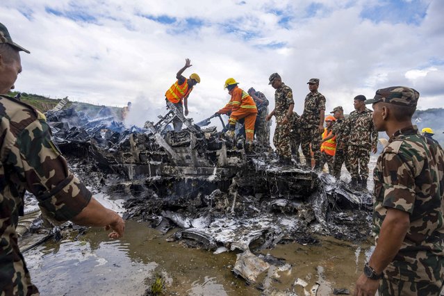 Nepal army personnel sort through the debris after a domestic plane belonging to Saurya Airlines crashed just after taking off at Tribhuvan International Airport in Kathmandu, Nepal, Wednesday, July 24, 2024. (Photo by Prabin Ranabhat/AP Photo)