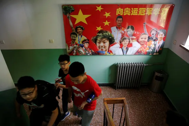 Students at the Shichahai sports school pass a poster featuring the school's former students who became Olympic champions, before their classes in Beijing, China, May 18, 2016. The poster reads “Learn from Olympic champions”. China's sports system has been enormously successful since the country returned to the Olympic fold in 1980, culminating with the host nation topping the medals' table at the 2008 Beijing Olympics. (Photo by Damir Sagolj/Reuters)