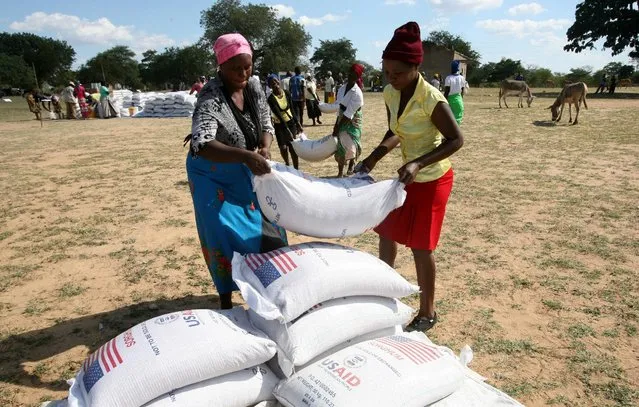 Villagers queue to collect their monthly food aid ration of cereals at a school in drought hit Masvingo, Zimbabwe, June 2, 2016. (Photo by Philimon Bulawayo/Reuters)