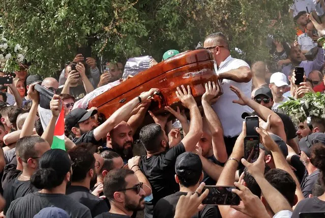 Mourners carry the coffin of slain veteran Al-Jazeera journalist Shireen Abu Akleh during her burial at the Mount Zion Cemetery outside Jerusalem's Old City on May 13, 2022, two days after she was killed while covering an Israeli army raid in the West Bank. (Photo by Hazem Bader/AFP Photo)