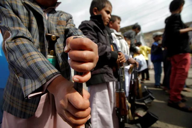 Boys hold weapons during a demonstration against the removal of the Saudi-led coalition from the United Nations annual child rights blacklist, outside the United Nations offices in Sanaa, Yemen, June 16, 2016. (Photo by Mohamed al-Sayaghi/Reuters)