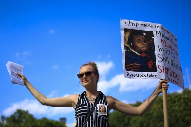 A protester takes part in a small rally at Union Square marking the first anniversary of the death of Michael Brown, an unarmed black teenager shot dead by a white police officer in Ferguson, Missouri a year ago, in New York August 9, 2015. (Photo by Eduardo Munoz/Reuters)