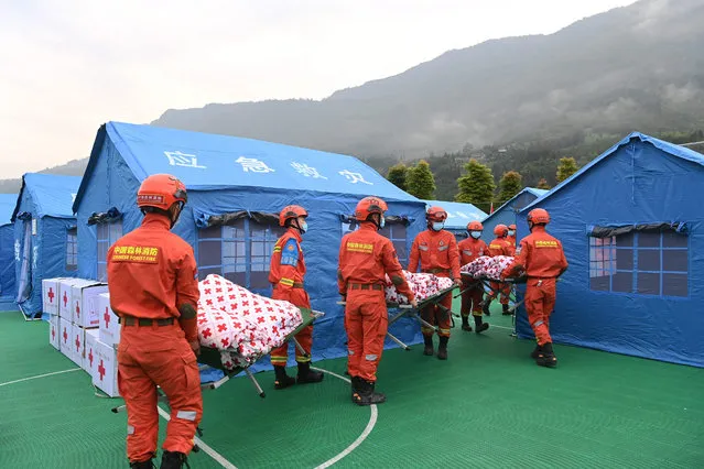 Rescue workers transfer supplies near tents set up for people displaced after a 6.1 magnitude earthquake in Yaan, in China's southwestern Sichuan province on June 2, 2022. (Photo by AFP Photo/China Stringer Network)