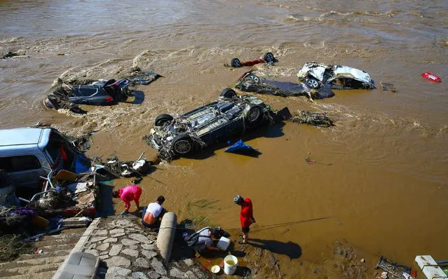 This photo taken on July 15, 2017 shows cars damaged by flooding in Yongji, a county under the administration of the city of Jilin in northeast China' s Jilin province. (Photo by AFP Photo/Stringer)