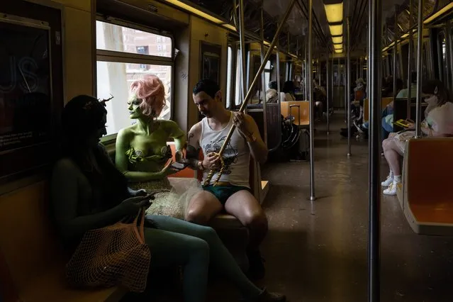 Performers ride on a train before the 40th annual Coney Island Mermaid Parade in the Brooklyn borough of New York, New York, USA, 18 June 2022. The annual event is one of the largest art parades in the country. (Photo by Yuki Iwamura/EPA/EFE)