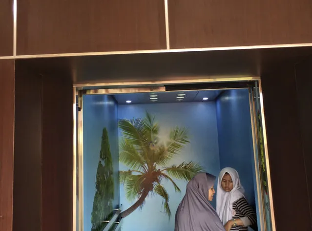 In this Friday, March 3, 2017 photo, Muslim women stand inside an elevator decorated with tree wallpapers at a hospital in Jakarta, Indonesia. (Photo by Dita Alangkara/AP Photo)