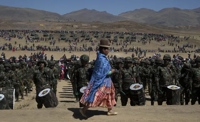 An Aymara indigenous female photographer covers a military parade commemorating the 192 anniversary of Bolivia's army in Kjasina, Bolivia, Monday, August 7, 2017. (Photo by Juan Karita/AP Photo)