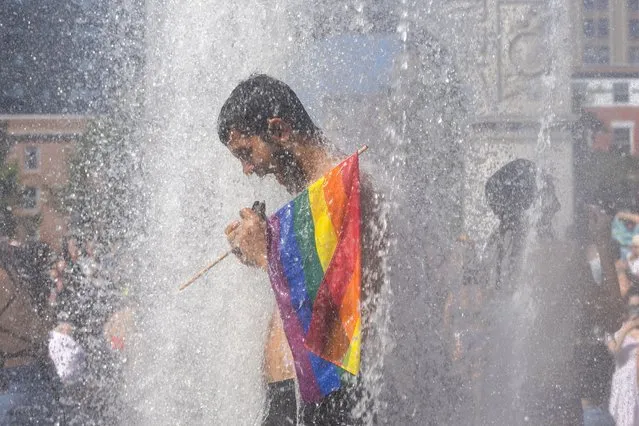 A man cools off in a fountain in Washington Square Park as people take part in the Queer Liberation March in New York City, New York, U.S., June 26, 2022. (Photo by Jeenah Moon/Reuters)