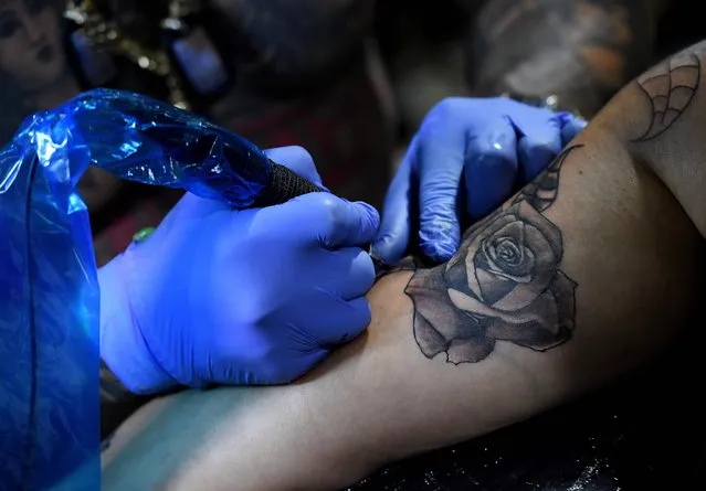 Tattoo artist Blaise Moreno from King Blaise Studio, works on a tattoo for Veronica Angel at the LA Tattoo Convention in Long Beach, California, on August 19, 2017. (Photo by Mark Ralston/AFP Photo)