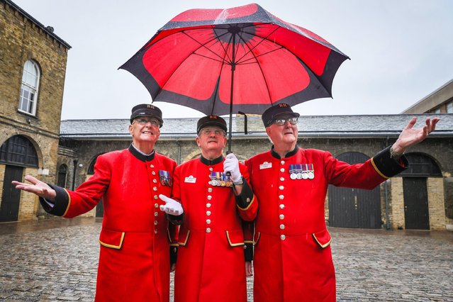 Chelsea Pensioners David Godwin (left) and Ted Fell (right) and Bert Weastell (middle) view the new Soane Stable Yard at the Royal Hospital Chelsea following a major refurbishment, unperturbed by the rain on September 27, 2024. The Chelsea History Festival returns to the historic Royal Hospital Road for its sixth year, from 25-29 Sep. It is a celebration of history and heritage across three venues: the National Army Museum, Royal Hospital Chelsea, and the Chelsea Physic Garden. (Photo by Imageplotter/Alamy Live News)