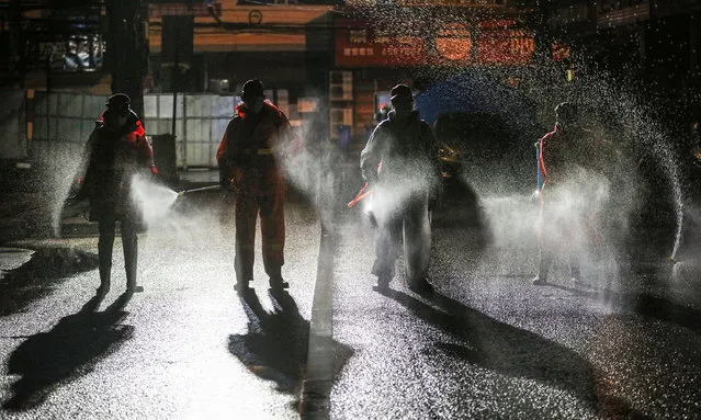 This photo taken on March 2, 2020 shows workers spraying disinfectant on a road in Yunmeng county, Xiaogan city, in China's central Hubei province. The world has entered uncharted territory in its battle against the deadly coronavirus, the UN health agency warned, as new infections dropped dramatically in China on March 3 but surged abroad with the US death toll rising to six. (Photo by AFP Photo/China Stringer Network)