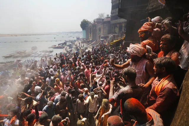 Devotees play Holi with ash and colors at a cremation ground on the banks of river Ganges at the Manikarnika Ghat in Varanasi, India, Friday, March 6, 2020. Thousands of Hindus celebrate their major festival Holi with ash collected from pyres in a cremation ground, following an age-old tradition. Hindu mythology says deity Shiva, known as “The Destroyer”, visited cremation grounds to play Holi with ghosts who couldn't celebrate the festival of colors. As per their tradition, Hindus burn the bodies of their dead in pyres of dry woods. (Photo by Rajesh Kumar Singh/AP Photo)