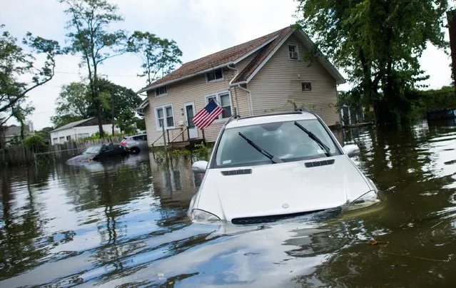 A car is abandoned on a flooded Reddington St. following heavy rains and flash flooding August 13, 2014 in Bayshore, New York. The south shore of Long Island along with the tri-state region saw record setting rain that caused roads to flood entrapping some motorists. (Photo by Andrew Theodorakis/Getty Images)