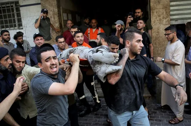 Mourners carry the body of Taiseer al-Jabari, Islamic Jihad commander, who was killed during Israeli airstrikes on his apartment in Gaza City, Friday, August 5, 2022. Palestinian officials say Israeli airstrikes on Gaza have killed several people, including a senior militant, and wounded 40 others. (Photo by Abdel Kareem Hana/AP Photo)