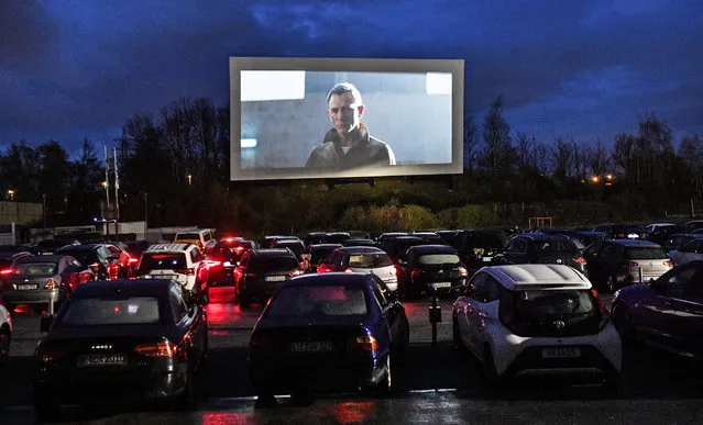 Hundreds of people sit in their cars watching a movie trailer at a drive-in cinema, as all other theaters in Germany are closed due to the coronavirus in Essen, Germany, on Monday, March 30, 2020. Only two persons are allowed per car, tickets are available only online and no snacks are sold to limit social contacts. (Photo by Martin Meissner/AP Photo)