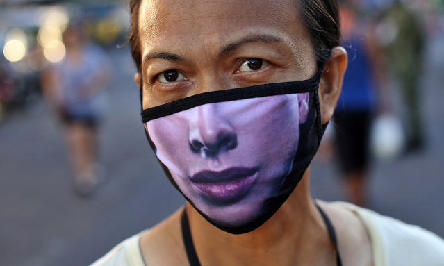 A Filipino woman wears a mask to try and protect against the spread of coronavirus in Malate district, Manila City on March 24, 2020. The Philippines has taken drastic measures to combat the spread of Covid-19. The entire country is under strict quarantine and the army is on the streets to monitor compliance. According to official figures, there are 462 positive cases and 33 dead in the Philippines, but it is thought that thousands of cases remain undetected due to lack of resources in a country where millions of people have no access to health care. In the poorest and most crowded areas, it’s almost impossible to adhere to the physical distancing required during quarantine. (Photo by Alejandro Ernesto/The Guardian)