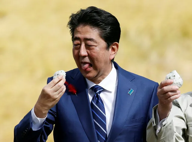 Japan's Prime Minister Shinzo Abe, who is also ruling Liberal Democratic Party leader, eats rice presented by local supporters during an election campaign rally in Fukushima, Japan, October 10, 2017. (Photo by Toru Hanai/Reuters)