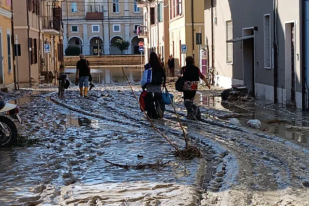 People walk on mud and debriS  in Senigallia, Italy, Friday September 16, 2022. Floodwaters triggered by heavy rainfall swept through several towns in a hilly region of central-east Italy early Friday, leaving 10 people dead and several missing, state radio said. Dozens of survivors scrambled onto rooftops or up trees to await rescue. (Photo by Gabriele Moroni/LaPresse via AP Photo)