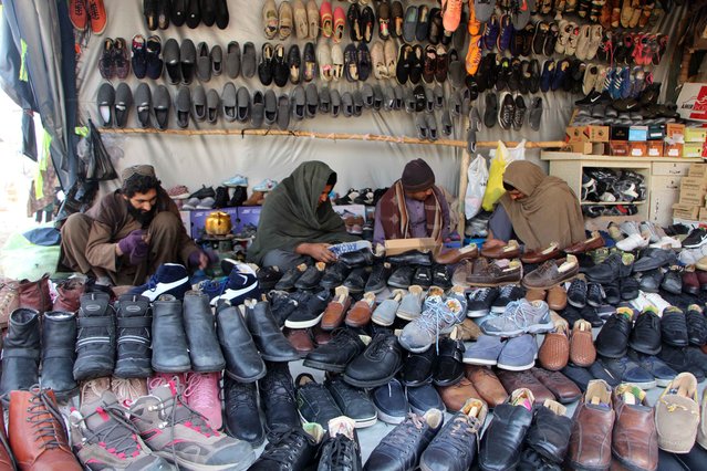 A vendor sells second-hand shoes at a roadside market in Kandahar, Afghanistan, 19 December 2024. Vendors selling second-hand clothes through auctions report a seasonal boost in sales due to the demand for affordable, high-quality winter wear amid economic struggles. (Photo by Qudratullah Razwan/EPA/EFE)
