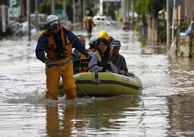 Local residents are rescued by firefighters at a residential area flooded by the Kinugawa river, caused by typhoon Etau in Joso, Ibaraki prefecture, Japan, September 11, 2015. (Photo by Issei Kato/Reuters)