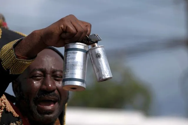A protester holds used tear gas canisters deployed by the Haitian National police during a protest demanding the resignation of Haiti's Prime Minister Ariel Henry after weeks of shortages in Port-au-Prince, Haiti on October 17, 2022. (Photo by Ricardo Arduengo/Reuters)