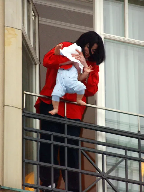 Singer Michael Jackson holds his eight-month-old son Prince Michael II over the balcony of the Adlon Hotel November 19, 2002 in Berlin, Germany. (Photo by Olaf Selchow)