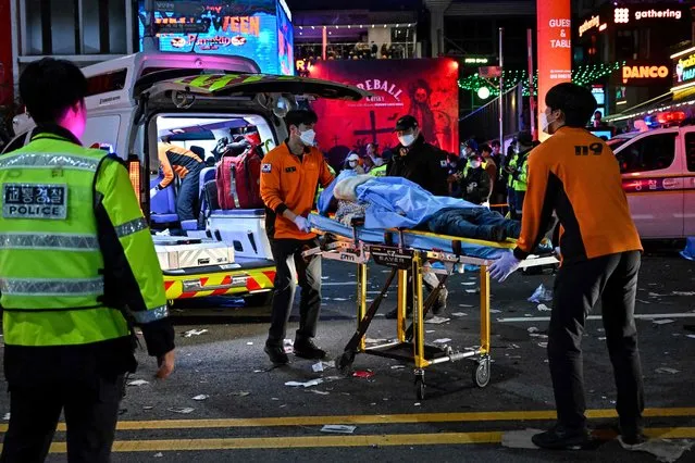 Medical staff transport a victim, believed to have suffered cardiac arrest, in the popular nightlife district of Itaewon in Seoul on October 30, 2022. (Photo by Jung Yeon-je/AFP Photo)