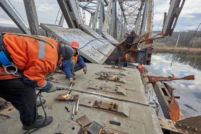 Workers repair a railway bridge after it was damaged in fighting between the Ukrainian and Russian armies in the town of Kupiansk, in Kharkiv region, Ukraine, 02 November 2022. The railway normally connects Kupiansk with Kharkiv which was retaken by the Ukrainian forces in September. Russian troops on 24 February entered Ukrainian territory, starting a conflict that has provoked destruction and a humanitarian crisis. (Photo by Sergiy Kozlov/EPA/EFE)