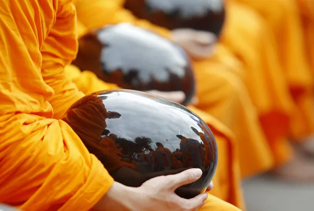 Thai Buddhist monkshold their alms bowls during an alms offering ceremony in Mandalay, Myanmar, September 20, 2015. Myanmar and Thailand offer alms to 10,000 Buddhist monks for first time in the Myanmar and Thailand history. (Photo by Hein Htet/EPA)