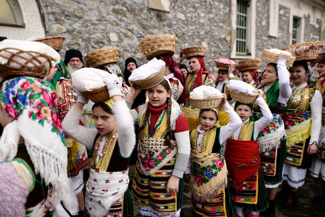 Women dressed in traditional folk costumes participate at the Epiphany day celebrations in the village of Bitushe, some 50km south-west of Gostivar, North Macedonia, on January 19, 2024. (Photo by Robert Atanasovski/AFP Photo)