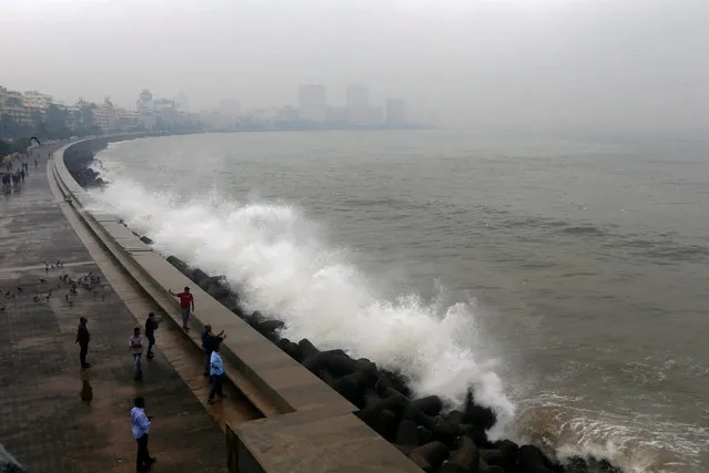 People take photographs of a large wave caused by Cyclone Ockhi in Mumbai, India, December 5, 2017. (Photo by Shailesh Andrade/Reuters)