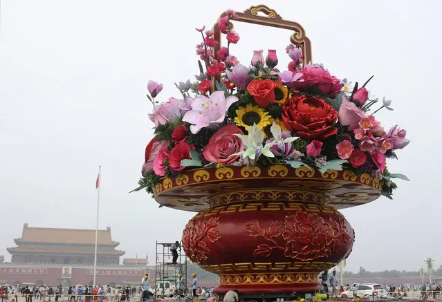Workers work on an installation in the shape of a giant flower basket to celebrate upcoming National Day, at Tiananmen Square in Beijing, China, September 24, 2015. China will mark the 66th anniversary of its founding on October 1. (Photo by Reuters/Stringer)