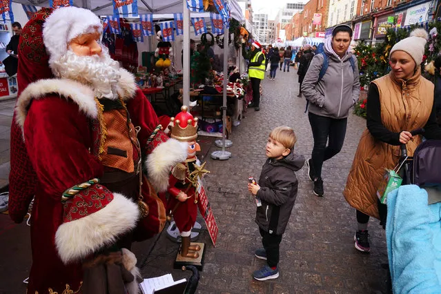 Alex Zozulia (3), from Chernihiv in Ukraine and living in Ireland since June of this year, stops to look at a model of Santa Claus at a stall on Moore street, Dublin on Saturday, December 3, 2022., as the Henry Street Christmas Market's were officially opened today. This longstanding Christmas tradition is the oldest Christmas market in Dublin and has been a part of the city centre Christmas shopping experience over the last few decades. (Photo by Brian Lawless/PA Wire)
