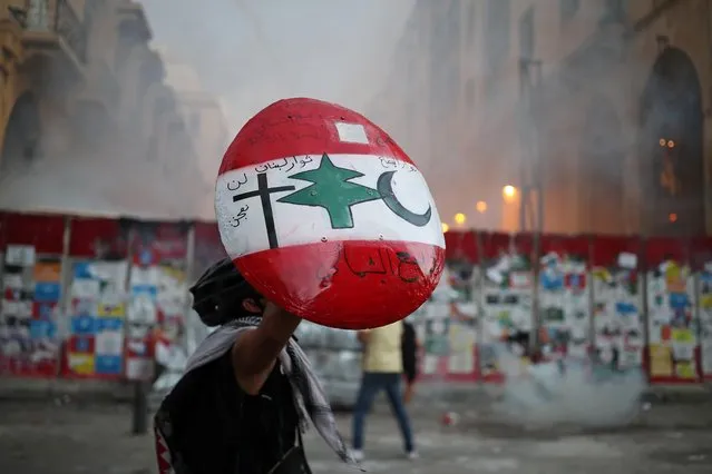 A demonstrator holds up a shield during anti-government protests that have been ignited by a massive explosion in Beirut, Lebanon on August 10, 2020. (Photo by Alkis Konstantinidis/Reuters)